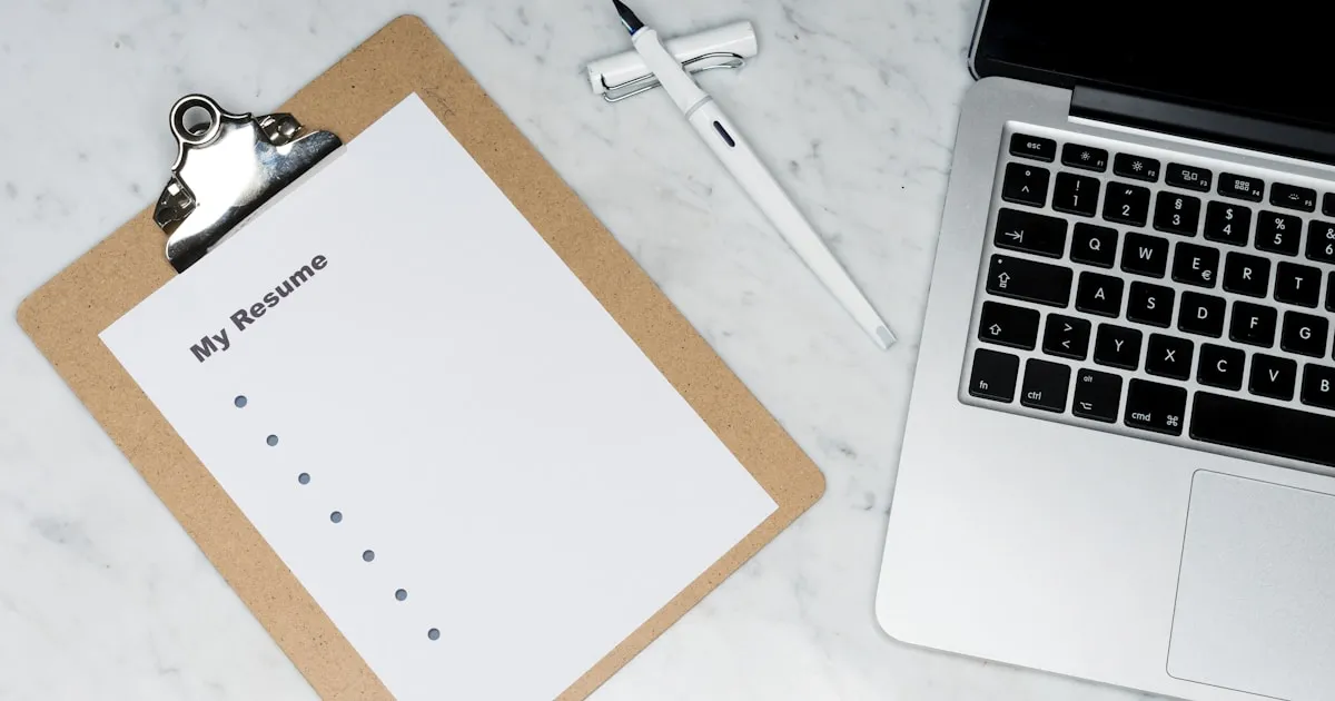 Document de cahier des charges posé sur un bureau avec stylo et ordinateur portable