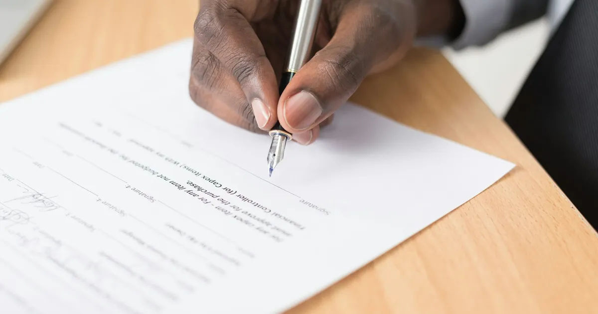 Dirigeant de PME signant un contrat de maintenance de site internet au stylo plume