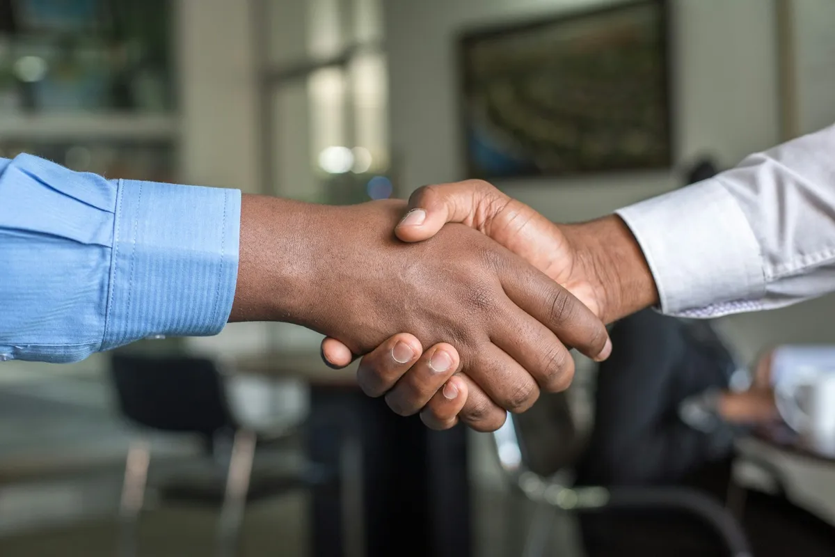 Poignée de main entre un dirigeant de PME et son prestataire après accord sur le contrat de maintenance